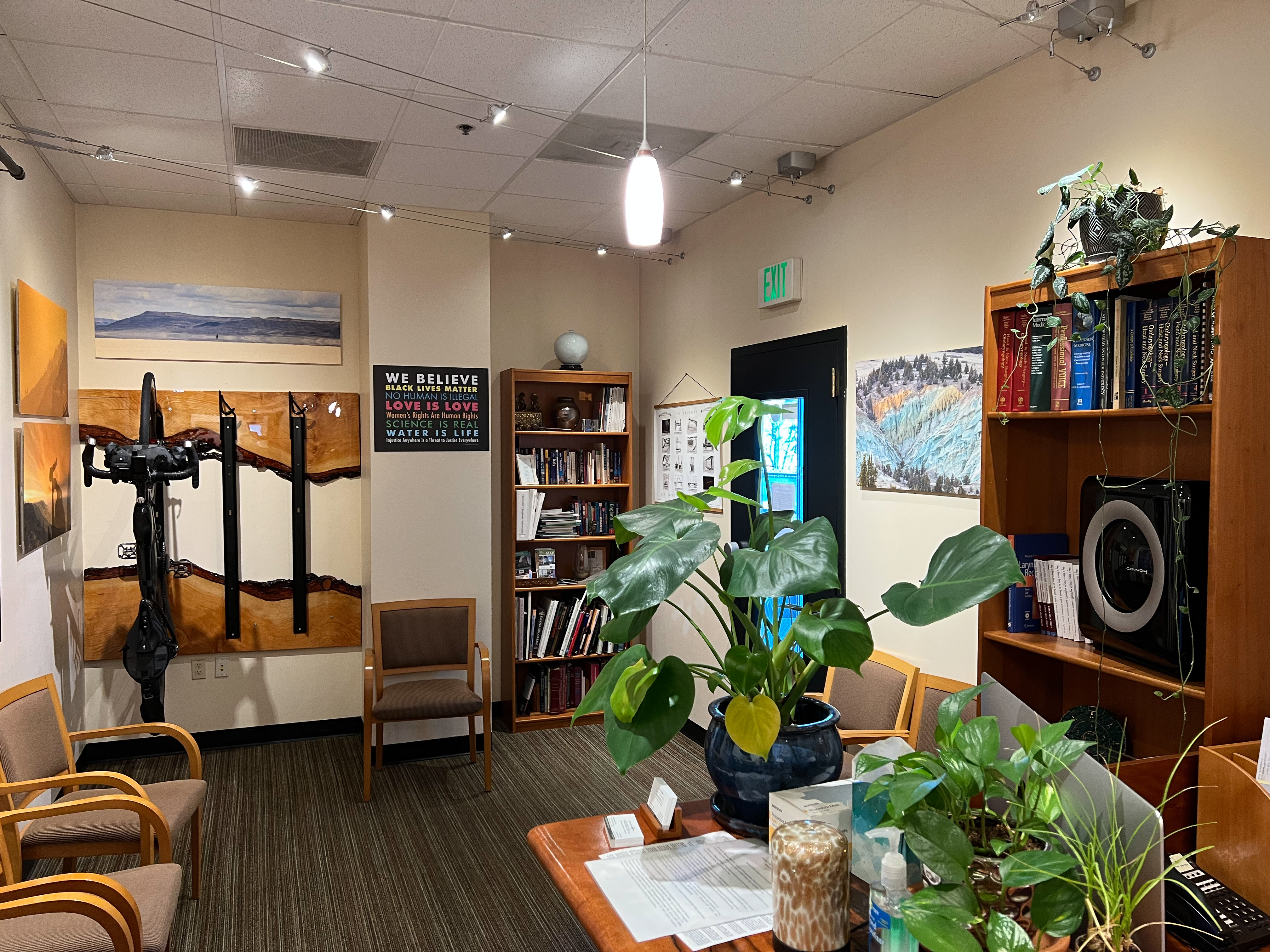 Waiting room with seating, indoor plants, and Pacific Northwest photography